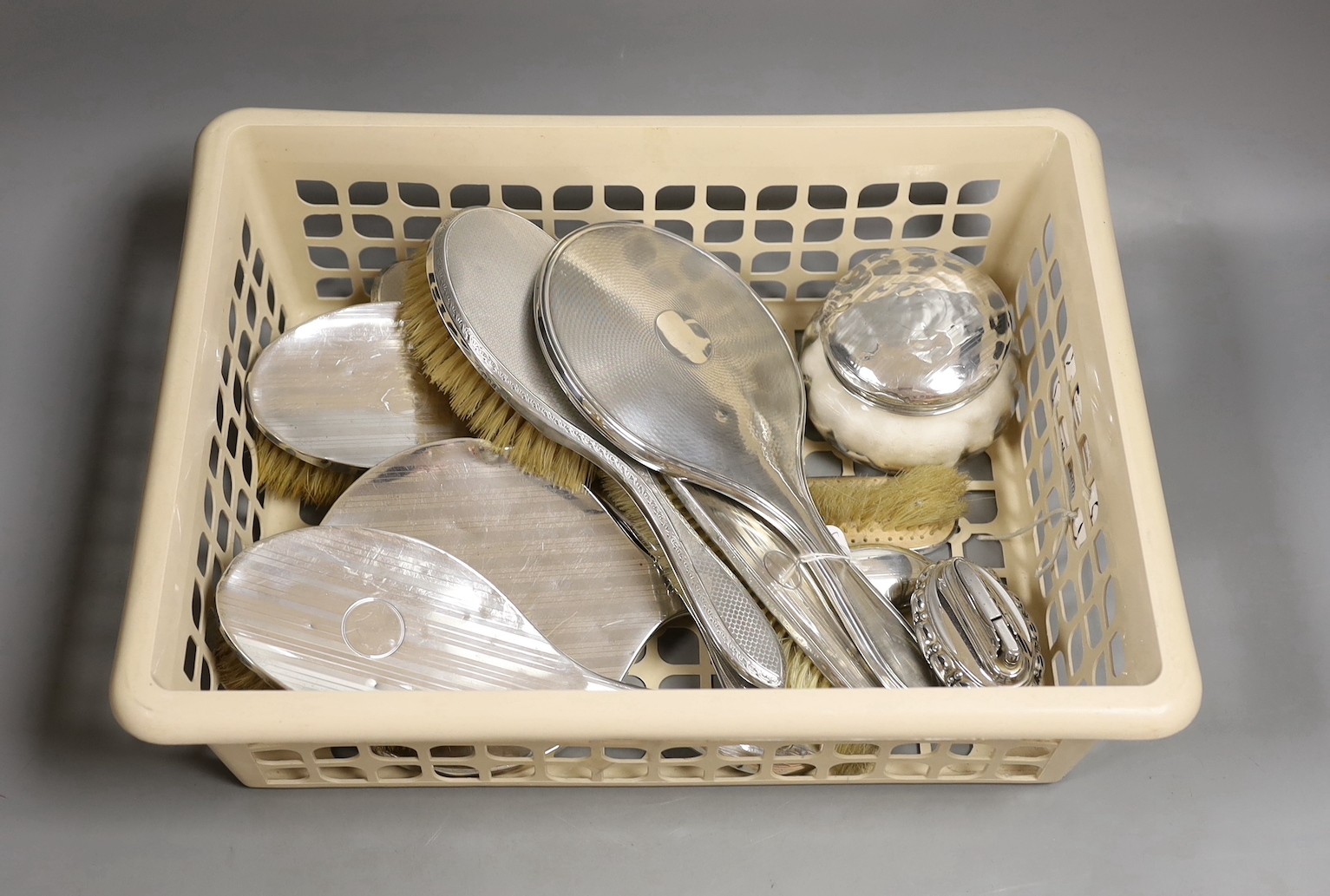 A George V silver mounted five piece mirror and brush set by A & J Zimmerman, five other silver mounted brushes, mirror and jar and a plated lighter.